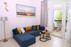 un soggiorno con divano blu e tavolo di 1BR Oasis at Starry Yas Supernova Apartment a Abu Dhabi