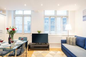 sala de estar con sofá azul y TV en Turnmill Apartments, en Londres