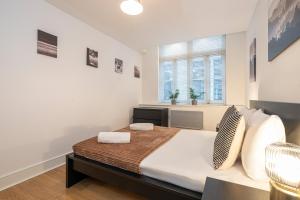 Un dormitorio con una cama grande y una ventana en Turnmill Apartments, en Londres
