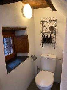 a bathroom with a white toilet and a window at Iconic Italian Townhouse w Rooftop Terrace, Pigna in Pigna