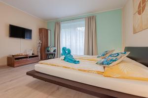 ein Schlafzimmer mit einem Bett mit einem ausgestopften Tier darauf in der Unterkunft Beach Design City Apartment Graz in Graz