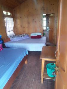 een kleine kamer met 2 bedden en een tafel bij Kabiraj Homestay by StayApart in Ghum