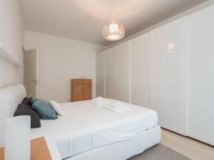 ein weißes Schlafzimmer mit einem großen Bett und weißen Schränken in der Unterkunft Youhosty - Grazioli 4 in Mailand