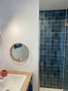een badkamer met een wastafel, een spiegel en een douche bij Maison les Acacias in Millau