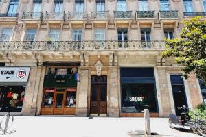 a building on a city street with some shops at Appartement Hyper centre 6 pax in Toulouse