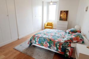 a bedroom with a bed and a yellow chair at Appartement Hyper centre 6 pax in Toulouse