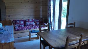 ein Wohnzimmer mit einem Sofa und einem Tisch in der Unterkunft Votre appartement savoyard de 32m2 à proximité de la télécabine pour skier les 3 Vallées ! in Villarlurin