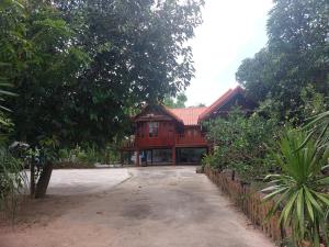 duży drewniany dom z podjazdem przed nim w obiekcie Duangmanee homestay 