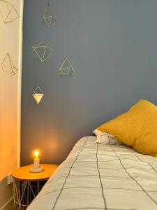 Un dormitorio con una cama con una vela sobre una mesa. en Appartement cosy et moderne - 2 Chambres, en Baugé