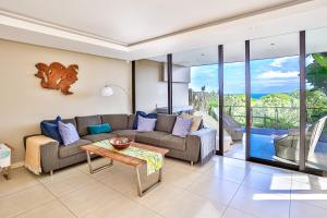 a living room with a couch and a table at Holiday home in Zimbali in Ballito