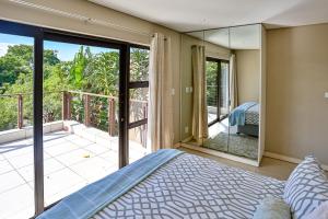 ein Schlafzimmer mit einem Bett und einem Balkon in der Unterkunft Holiday home in Zimbali in Ballito