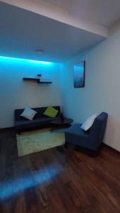 ein Wohnzimmer mit Sofa und blauem Licht in der Unterkunft Elegante Departamento in La Paz