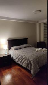 een slaapkamer met een bed en een tafel met een lamp bij Elegante Departamento in La Paz