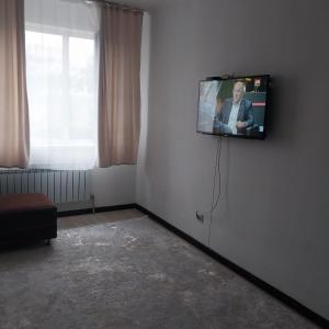 een televisie aan een muur in een kamer bij жк Утеген in Alma-Ata