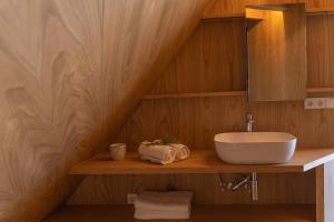 uma casa de banho com um lavatório numa prateleira de madeira em Cabañas de Xarás - Margarida em Marín