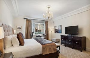 a bedroom with a large bed and a flat screen tv at The Sherry Netherland in New York