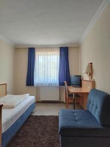 um quarto de hotel com uma cama e uma secretária com um computador em Gasthof zur Länd em Moosburg