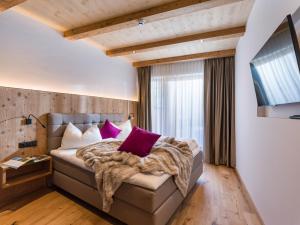 a bedroom with a large bed with purple pillows at Das Bergjuwel in Auffach