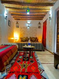 un soggiorno con letto e tavolo di Riad Alamine a Marrakech