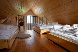 um quarto com 2 camas num quarto de madeira em Meditrine em Milotice