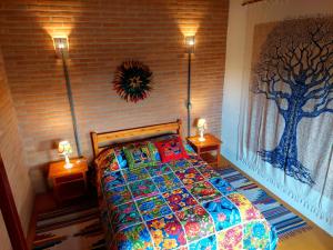 a bedroom with a bed with a tree mural on the wall at Chalé Ganesh - O chalé é maravilhoso! in Cunha