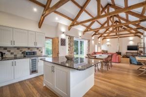 a kitchen with white cabinets and a living room at Kilnmark Bothy in Thornhill