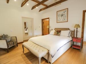 ein Schlafzimmer mit einem großen weißen Bett und einem Stuhl in der Unterkunft Kilnmark Bothy in Thornhill