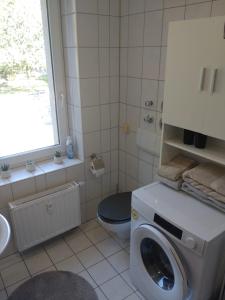 a bathroom with a washing machine and a toilet at fewo-Grychnik in Dresden