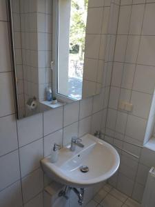 a white bathroom with a sink and a mirror at fewo-Grychnik in Dresden