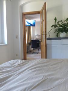 a bedroom with a white bed and a desk at fewo-Grychnik in Dresden