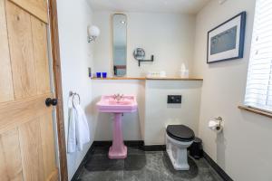 a bathroom with a pink sink and a toilet at The Cartford Inn in Great Eccleston