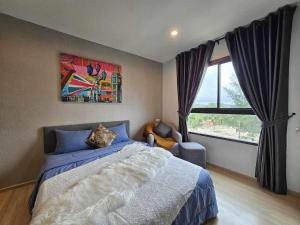 ein Schlafzimmer mit einem Bett und einem großen Fenster in der Unterkunft Zcape1 Condo Bangtao Beach in Ban Thalat Choeng Thale