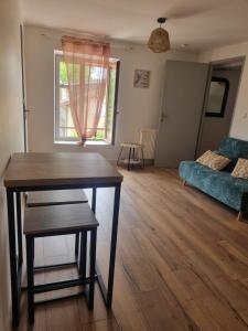 a living room with a table and a couch at APPARTEMENT COSY in Moncey