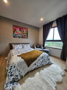 ein Schlafzimmer mit einem großen Bett und einem Fenster in der Unterkunft Zcape1 Condo Bangtao Beach in Ban Thalat Choeng Thale