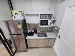 eine kleine Küche mit Spüle und Kühlschrank in der Unterkunft Zcape1 Condo Bangtao Beach in Ban Thalat Choeng Thale