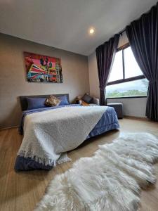 ein Schlafzimmer mit einem Bett und einem weißen Teppich in der Unterkunft Zcape1 Condo Bangtao Beach in Ban Thalat Choeng Thale