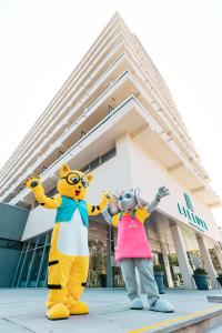 dos mascotas de pie frente a un edificio en Lielupe Hotel SPA & Conferences by Semarah en Jūrmala