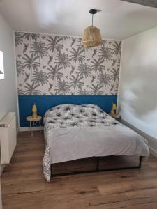 een slaapkamer met een bed met een blauwe en witte muur bij APPARTEMENT COSY 