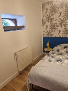 een slaapkamer met een bed en een muur met palmbomen bij APPARTEMENT COSY 