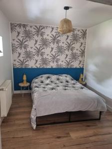 een slaapkamer met een groot bed met een blauwe muur bij APPARTEMENT COSY 
