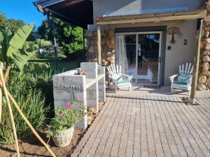 a porch of a house with two white chairs at Angel 8 AirBnB Apartment 2 in Robertson