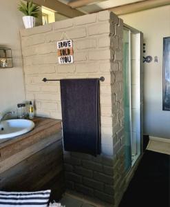 ein Badezimmer mit einer Backsteinwand und einem Waschbecken in der Unterkunft Angel 8 AirBnB Apartment 2 in Robertson