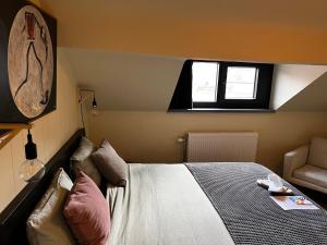ein Schlafzimmer mit einem Bett, einer Couch und einem Fenster in der Unterkunft Cozy Boutique hotel-Guesthouse Leuven -self check in in Löwen