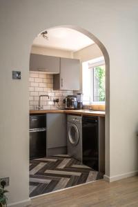 an archway in a kitchen with a washing machine at Entire 2 Bed Apartment in Manchester in Manchester