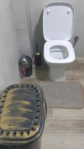 La salle de bains est pourvue de toilettes blanches et d'un tapis. dans l'établissement Mavrovo Centar Ski Staza, à Mavrovo