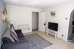 uma sala de estar com um sofá e uma televisão de ecrã plano em Entire 2 Bed Apartment in Manchester em Manchester