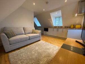 a living room with a couch and a kitchen at The Cotswold Stowaway, Perfect Luxurious Retreat! in Stow on the Wold