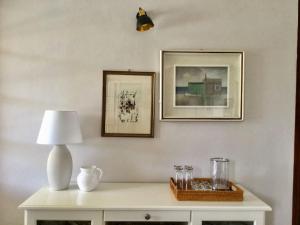 une table blanche avec une lampe et des photos sur le mur dans l'établissement House with a swimming pool - Villa San Giorgio, à Villa Gorizia
