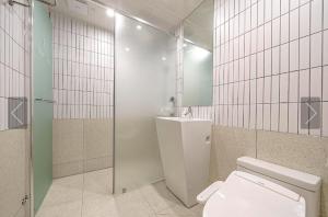 uma casa de banho com um WC, um chuveiro e um lavatório. em Brown Dot Hotel Yeonsan em Busan