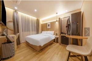 a hotel room with a bed and a table and a chair at Brown Dot Hotel Yeonsan in Busan +1 photo